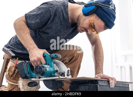 Circular Saw, carpenter using a circular saw for wood. Stock Photo