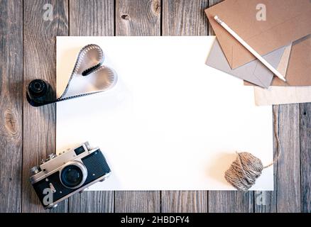 Flat lay background with retro camera and letters on wooden surface. Stock Photo