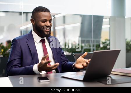 Happy black businessman having video chat, using laptop Stock Photo