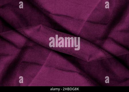 Moody dark pink color textile texture on twisted silk fabric for background Stock Photo
