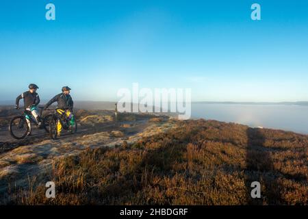 Ilkley, Yorkshire UK, 19 December 2021 - Cyclists turn back to see rare brocken spectre weather phenomenon on Ilkley Moor. Credit: Rebecca Cole/Alamy Live News