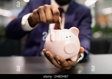 Unrecognizable african american man in suit making savings Stock Photo