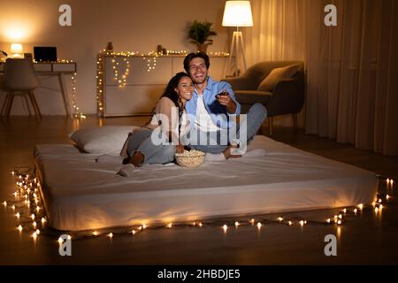 Couple Having Fun Watching Movie On TV At Home Stock Photo