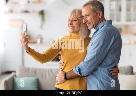 Smiling Mature Couple Making Selfie On Phone At Home Stock Photo