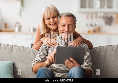 Senior Husband And Wife Using Digital Tablet Together At Home Stock Photo