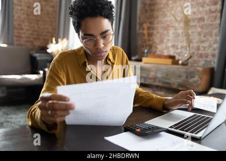 Focused young African American woman managing financial affairs. Stock Photo