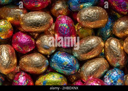 Full-frame close-up on a stack of colorful foil wrapped chocolate Easter eggs Stock Photo