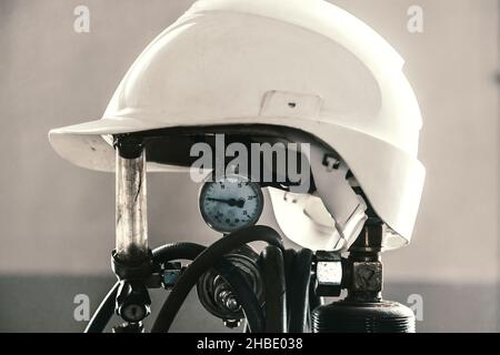 Construction helmet is worn on oxygen cylinder in welding shop. Industry and construction. Background. Stock Photo