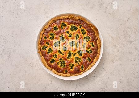 Quiche pie with broccoli, tuna and cheese in white baking dish. Flat lay Stock Photo