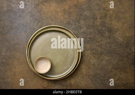 Empty green ceramic two plates and saucepan one in one on rustic background, copy space, top view Stock Photo