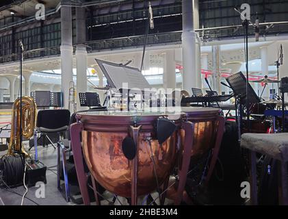 Copper drums with band or orchestra instruments and empty chairs arranged ready for a recital or concert in a close up view Stock Photo