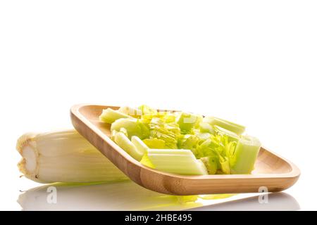 Green ripe organic celery stalks on a bamboo plate, close-up, isolated on white. Stock Photo