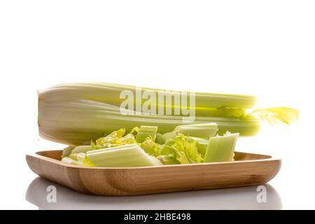 Green ripe organic celery stalks on a bamboo plate, close-up, isolated on white. Stock Photo