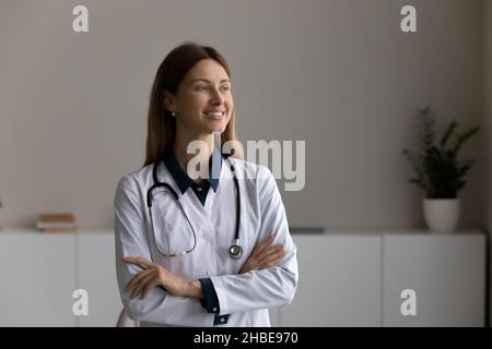Confident young woman doctor stand in office with crossed arms Stock Photo
