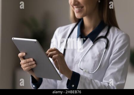 Happy female doctor attending physician making electronic prescription on touchpad Stock Photo