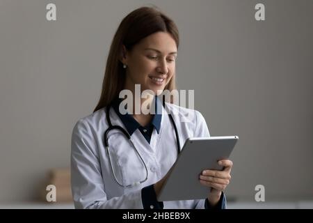 Happy modern day woman medic work at web on pad Stock Photo