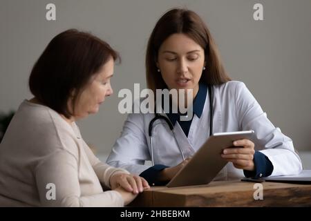 Female doctor show test result on tablet pc to patient Stock Photo