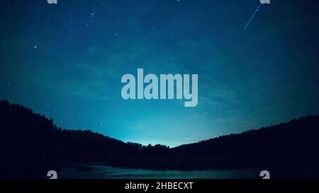 Stars over the lake at summer night on dark sky. Starfall. Amazing milky way galaxy with big amount of stars. Star trails, beautiful blue night, Star Stock Photo