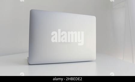 Rear view of a white laptop isolated on white background. Modern slim design of a new laptop made of aluminum material on white table, concept of mode Stock Photo