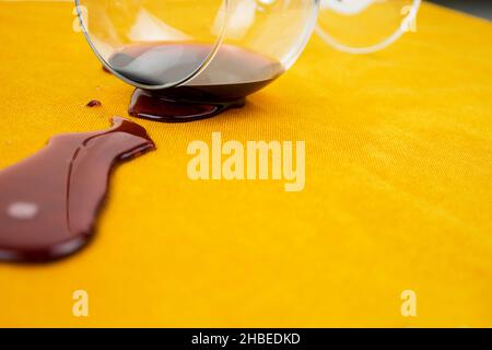 a spilled glass of wine on the tablecloth. Cleaning clothes and furniture from stains Stock Photo