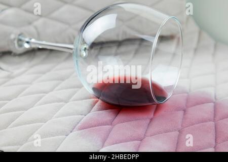 a spilled glass of wine on the tablecloth. Cleaning clothes and furniture from stains Stock Photo