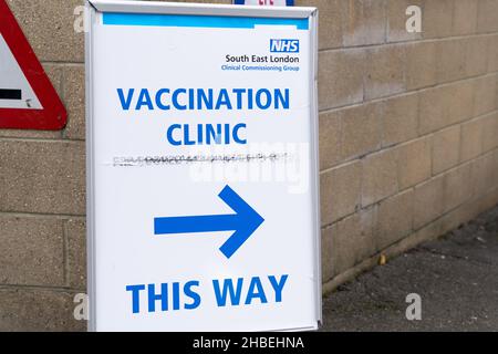 Greenwich London UK 19 December 2021. Southeast London clinical Commissioning group rolls out this weekend covid-19 vaccination for all eligible adults at The Valley, Charlton Athletic FC. Two young women dressed up on Stilts performing at the entrance to vaccine centre welcome people to get vaccinated to stop the surge of Omicron variant of coronavirus in the winter leading up to Christmas festive season. Credit: Xiu Bao/Alamy Live News Stock Photo