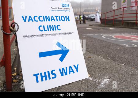 Greenwich London UK 19 December 2021. Southeast London clinical Commissioning group rolls out this weekend covid-19 vaccination for all eligible adults at The Valley, Charlton Athletic FC. Two young women dressed up on Stilts performing at the entrance to vaccine centre welcome people to get vaccinated to stop the surge of Omicron variant of coronavirus in the winter leading up to Christmas festive season. Credit: Xiu Bao/Alamy Live News Stock Photo