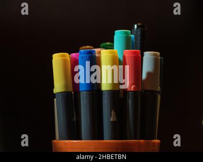 Colored caps of felt-tip pens on dark background Stock Photo