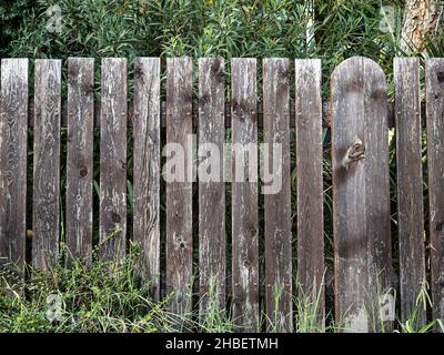 Old low and painted fence on cloudy day front view Stock Photo