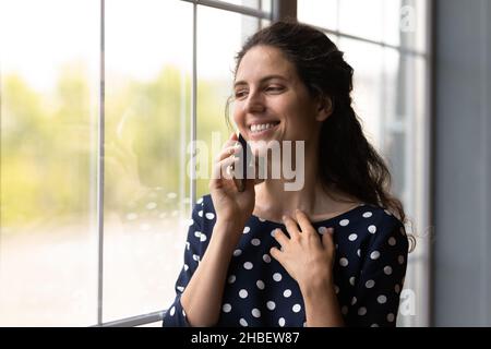 Smiling cheerful young hispanic woman holding cellphone call. Stock Photo