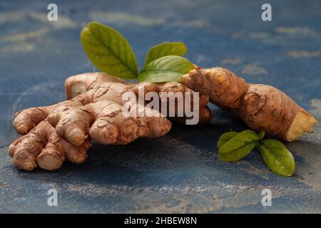 Fresh ginger root and on blue background. Healthy condiment for cooking and immunity. Stock Photo