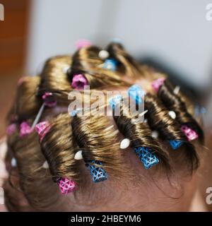 Woman head with plastic hair rollers seen from above. Short hair Stock Photo