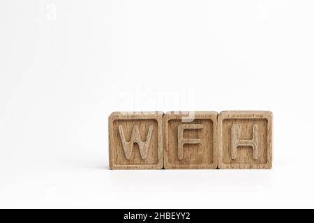 WFH (work from home) theme. wooden cubes with the acronym WFH, on white background. photo with space for text Stock Photo