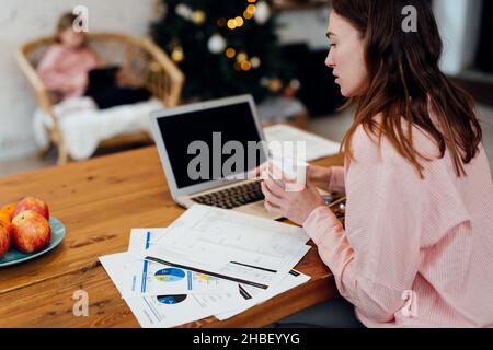 Young woman working in the kitchen at home during the winter vacations Stock Photo