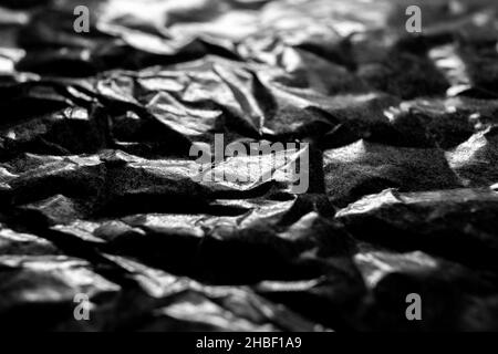 Wrinkled grungy black paper texture. Macro shot. Selective focus Stock Photo