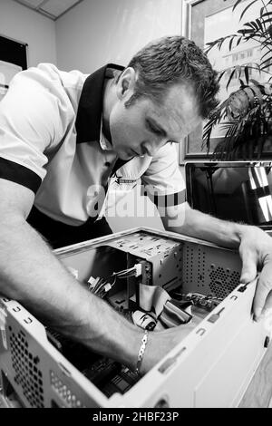 JOHANNESBURG, SOUTH AFRICA - Aug 09, 2021: IT service and maintenance professional working on a desktop computer Stock Photo