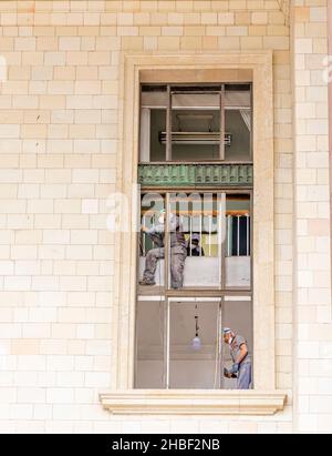 Workers working on renovating repairing large window of Stalinist architecture-Moscow State University building, Moscow, Russia Stock Photo