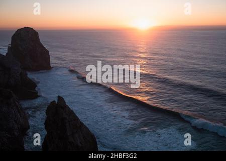 View of the rocks rasing in amazing sunset light at Atlantic coast in Portugal near Cabo Da Roca. Stock Photo