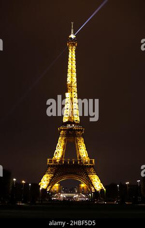 Eiffel Tower Lit Up at Night with Search Light Stock Photo