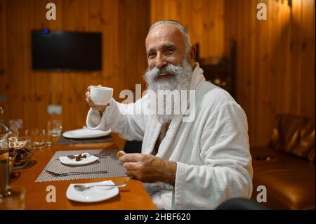 Senior man drinking tea rest in sauna Stock Photo