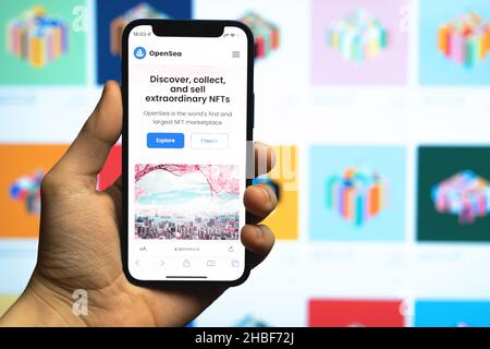 Kharkov, Ukraine - December 17, 2021: Man uses OpenSea marketplace for NFT selling. Website with logo closeup on mobile phone screen. Concept of crypt Stock Photo