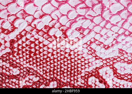 Ecsotic reptile skin pattern on genuine leather close-up, surface of bright red color Stock Photo