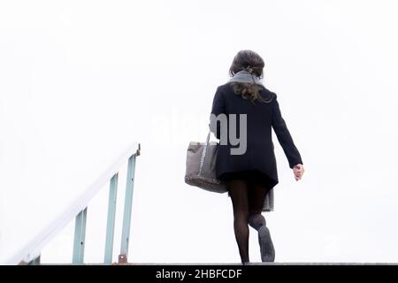 Businesswoman going up the stairs to work. Stock Photo