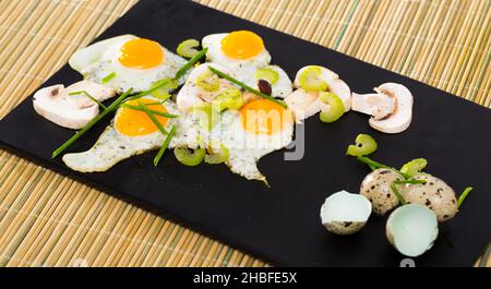 Fried quail eggs with champignons Stock Photo