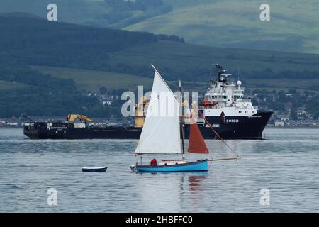 Carrie, a gaff rigged sailing yacht, passing Greenock Esplanade on the Firth of Clyde, with SD Northern River in the background Stock Photo