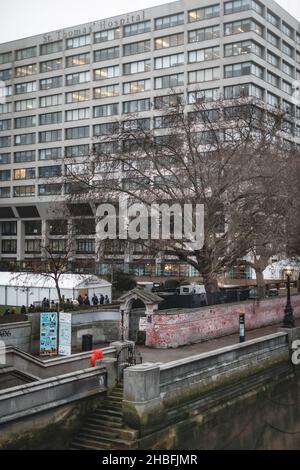 Queues begin to gather early in the morning to get their booster jab at St. Thomas' Hospital in London, and on the outside a view of the Covid Wall. Stock Photo