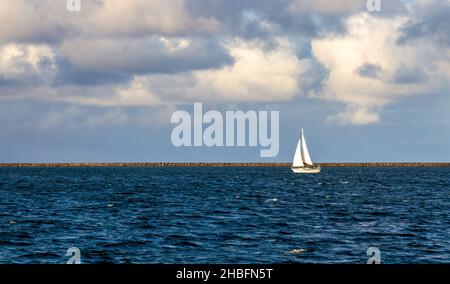Sailboat sailing in the calm waters of Hilo Bay on Big Island, Hawaii Stock Photo
