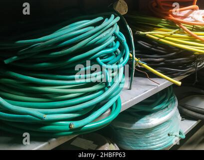 Electric wires of different cross-sections and colors are wound in rings close-up Stock Photo