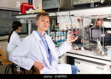 Young male scientist sitting at biochemical lab Stock Photo