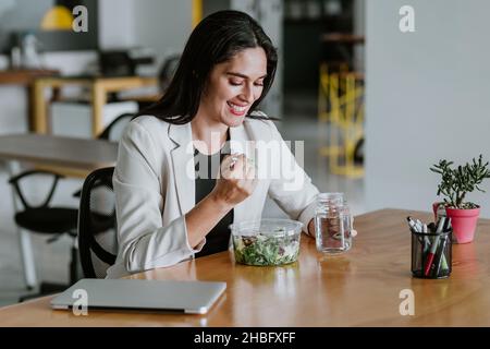 https://l450v.alamy.com/450v/2hbfxff/latin-adult-woman-eating-salad-lunch-at-the-office-in-mexico-latin-america-2hbfxff.jpg